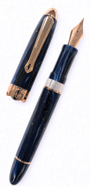 Nahvalur Horizon fountain pen in dark blue with a marbled, pearlescent finish and rose gold trim, shown with its cap removed.