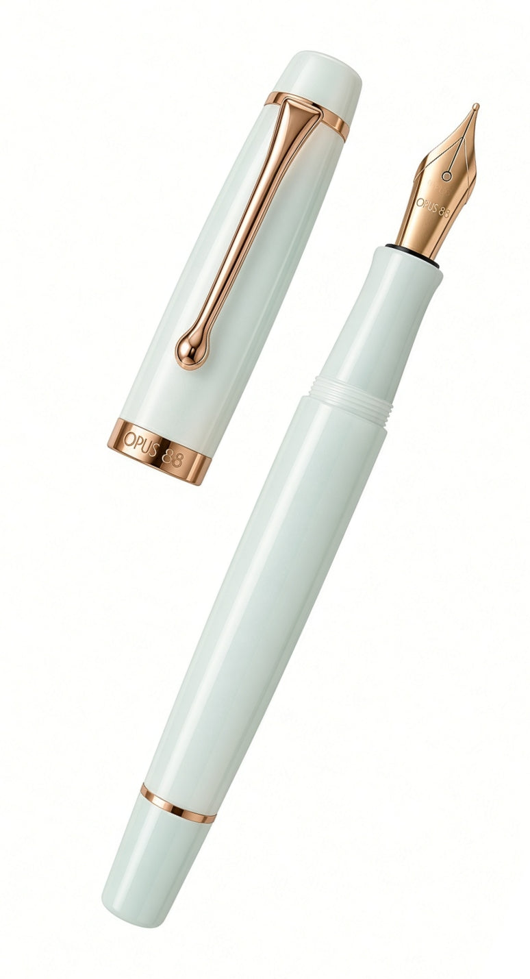 Opus 88 Harmony fountain pen in light green with rose gold trim, shown with its cap removed and its eyedropper-filled reservoir visible.