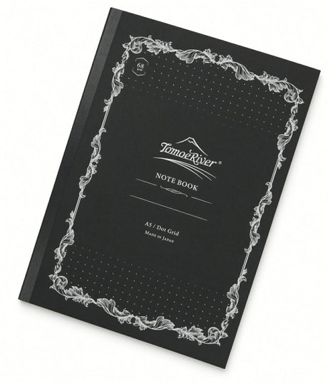Tomoe River A5 Notebook - Dot Grid (68gsm) with a black dot grid cover, white ornate border, and a central label reading NOTE BOOK with A5 / Dot Grid text below.