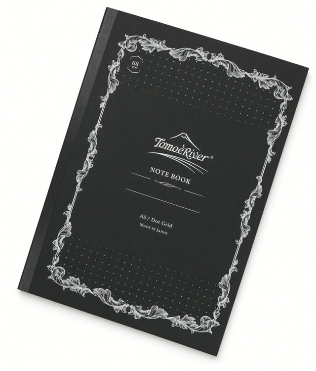 Tomoe River A5 Notebook - Dot Grid (68gsm) with a black dot grid cover, white ornate border, and a central label reading NOTE BOOK with A5 / Dot Grid text below.
