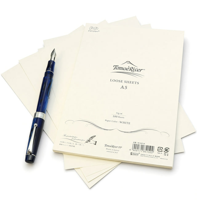 A stack of white Tomoe River A5 Loose-leaf Sheets (52gsm) with a blue fountain pen resting on top.